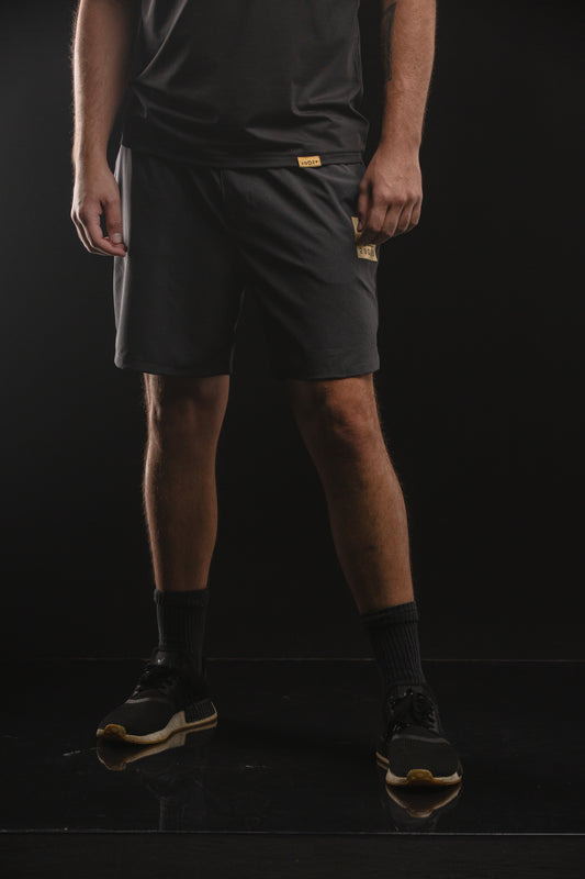 Black performance shorts with a gold square screen print on the left upper thigh featuring the black 29029 logo.